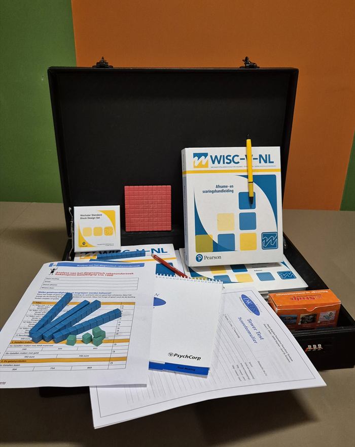Geopende diagnostiekkoffer met WISC-V-NL testmateriaal, blokken en scoreformulieren