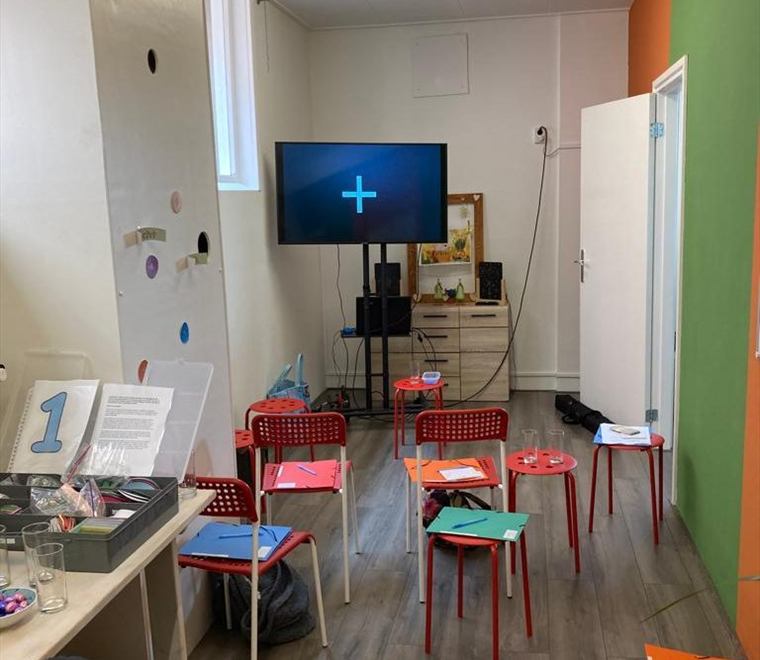 Een lokaal ingericht voor een escaperoom, met genummerde werkplekken en opdrachtmateriaal