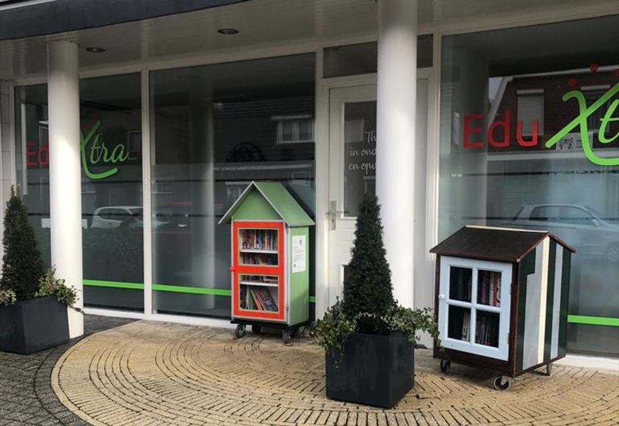 De voorgevel van EduXtra met twee smokkelboekenkasten naast de ingang